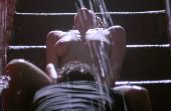Kim Basinger con el pecho desnudo mientras Mickey Rourke le practica sexo oral