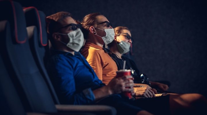 Sala de cine llena de espectadores con mascarilla